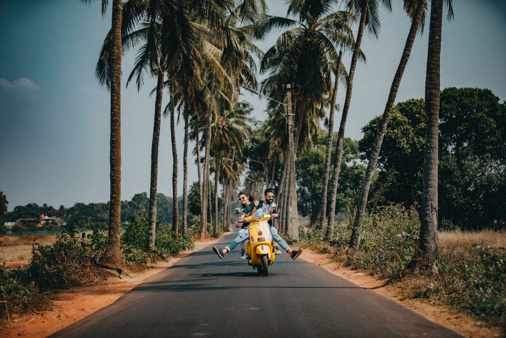 two people riding on a scooter, motor scooter, yellow scooter, island, riding a motor scooter on an island